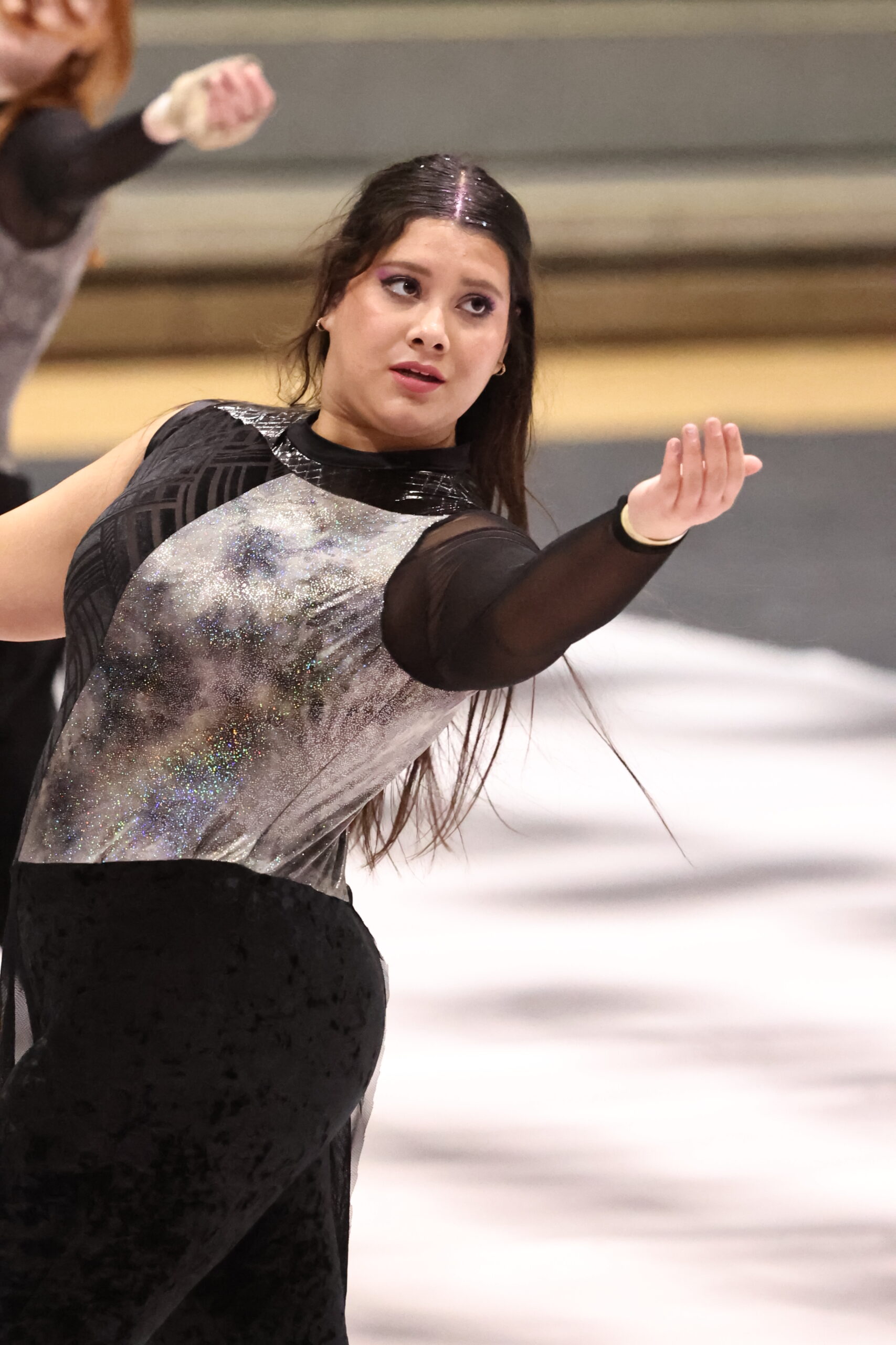 Belding High School winter guard member performing with a pastel flag
